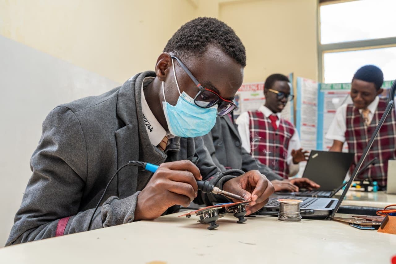 Precious Schools student soldering a robotics component during a hands-on technology session