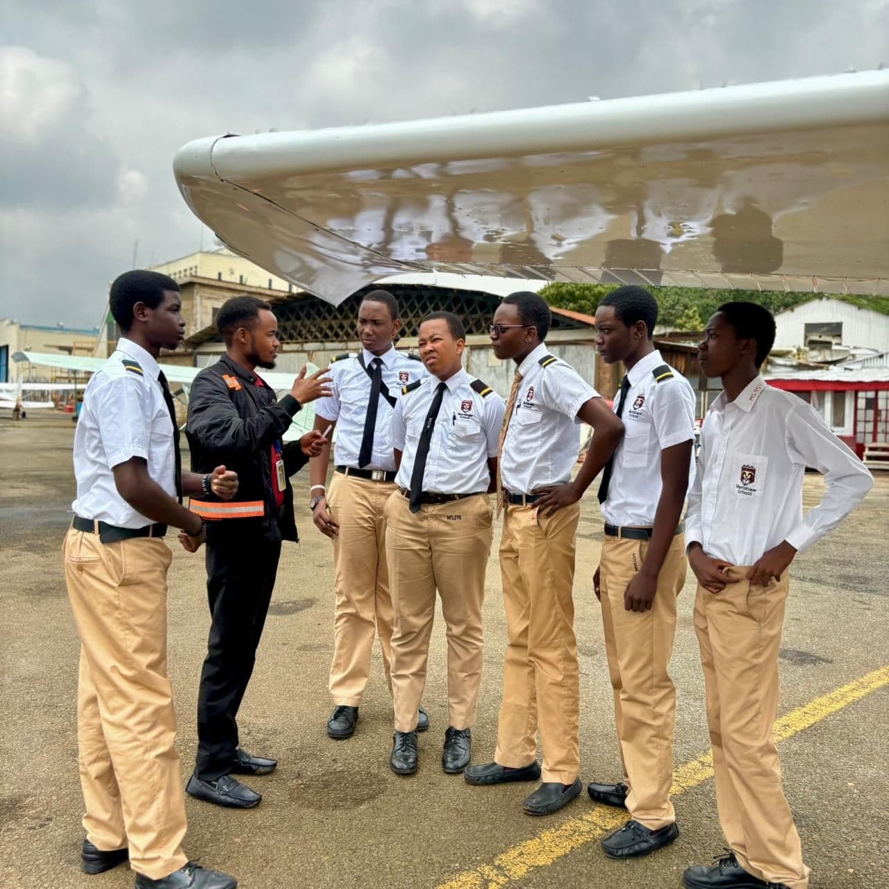 Precious Schools aviation students receiving a briefing beside an aircraft