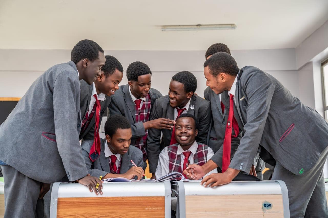 Precious Schools students collaborating around a classroom desk